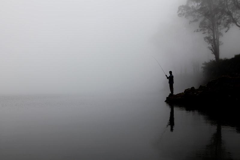 Рыбак на фоне реки в тумане
