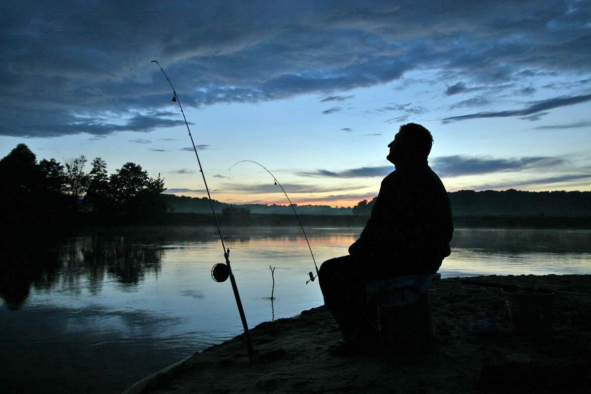 Рыбак с закидушками на закате