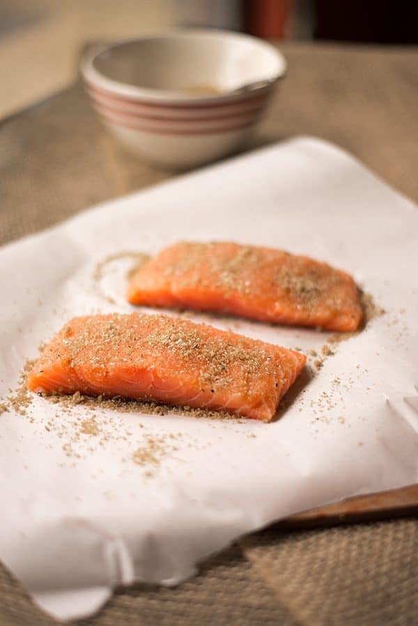 Spice-rubbed raw salmon fillets with their skin on, ready to make pan-fried salmon dish 